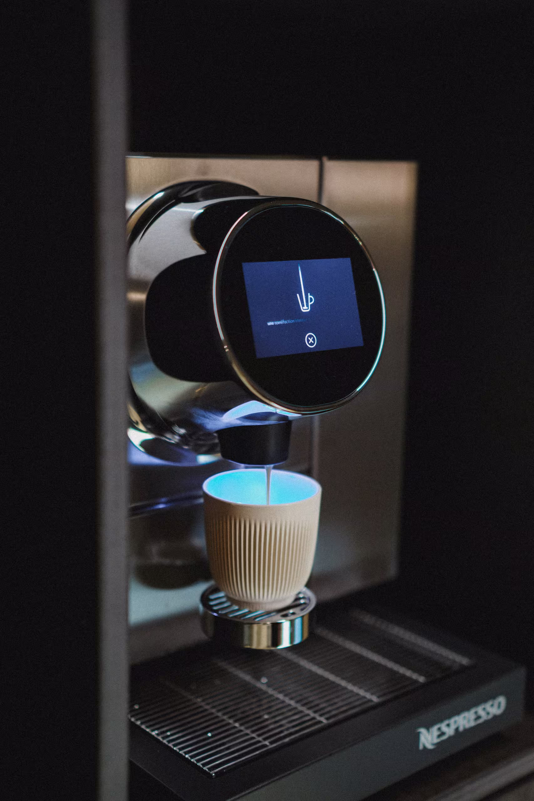 Machine à café Nespresso moderne préparant un expresso dans une tasse design, confort moderne et service hôtelier 4 étoiles en cabine éco-responsable.