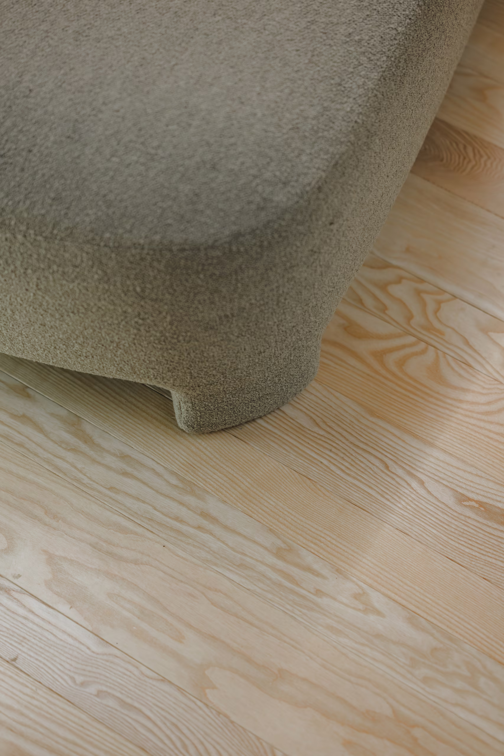 Gros plan sur le mobilier et le parquet en bois clair d'une suite SNUUG, mettant en avant la qualité des matériaux naturels et le design épuré.