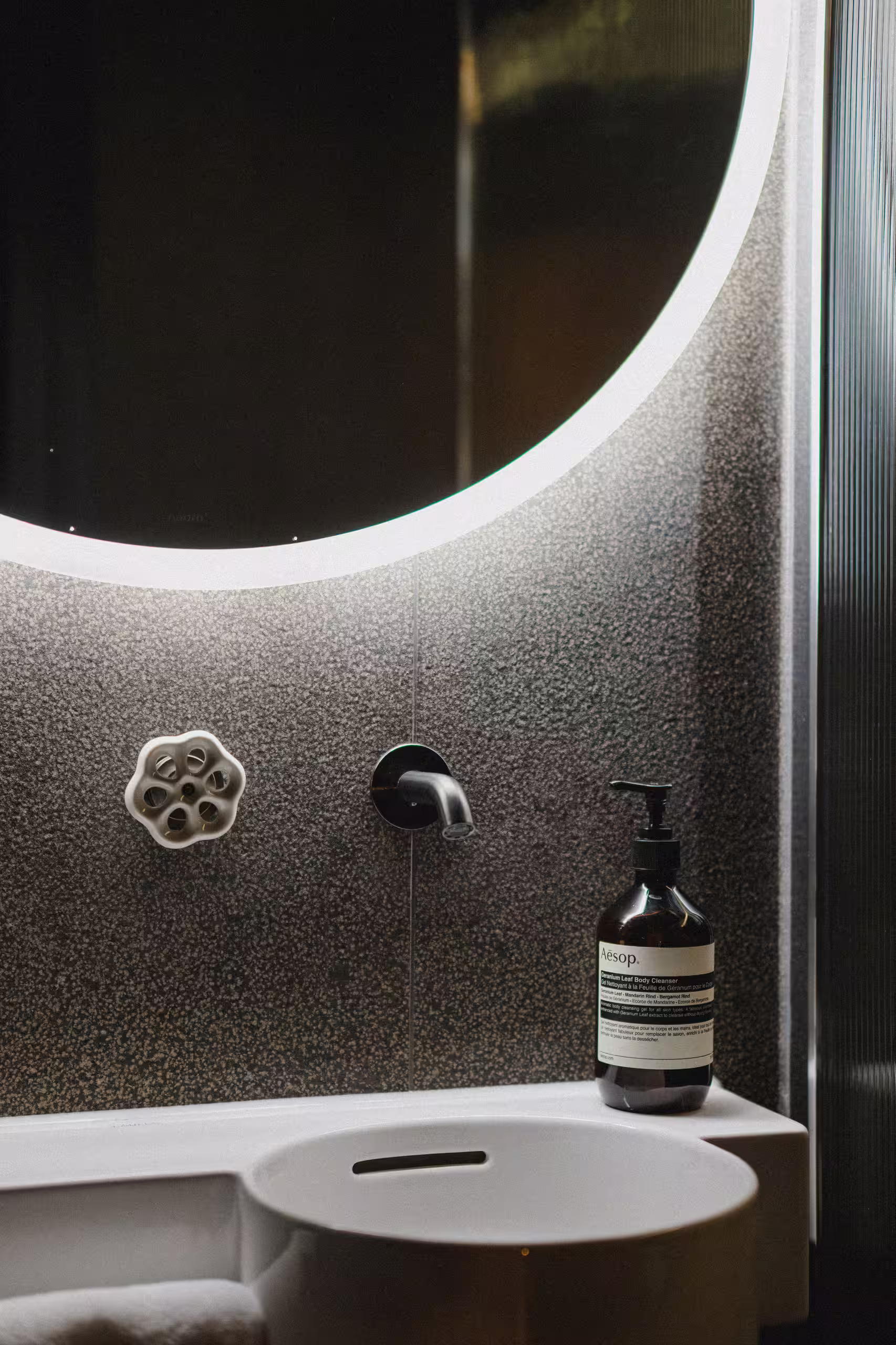 Espace lavabo moderne avec produits de soin Aesop dans une suite SNUUG, alliant luxe, bien-être et respect de l'environnement en pleine nature.