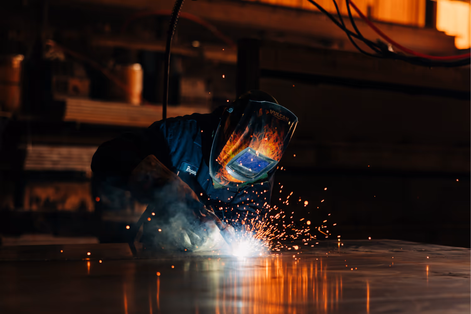 A welder welding a roll-off container floor