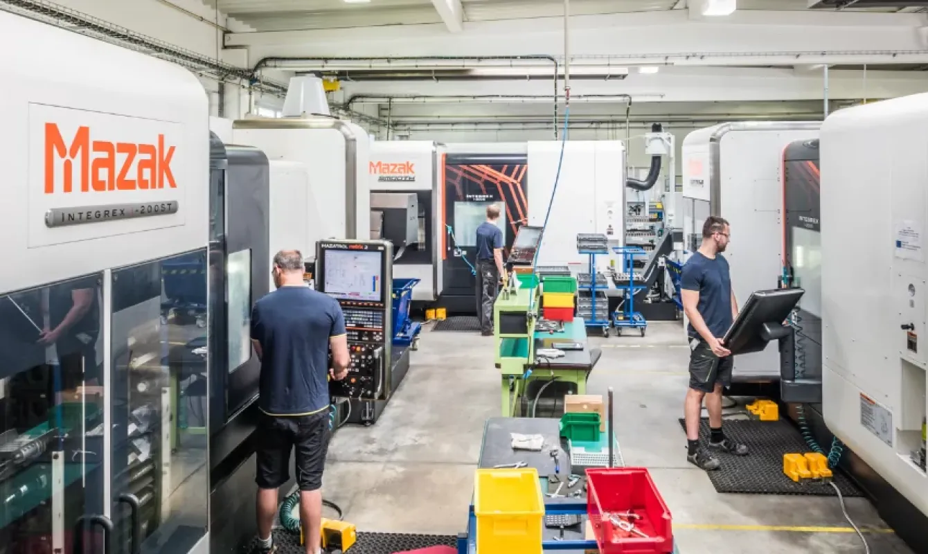 A group of men working on machinery in a factory