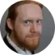 A man in a suit and tie with a crown on his head