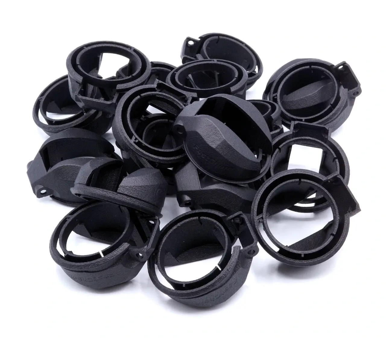 A pile of black plastic objects on a white surface