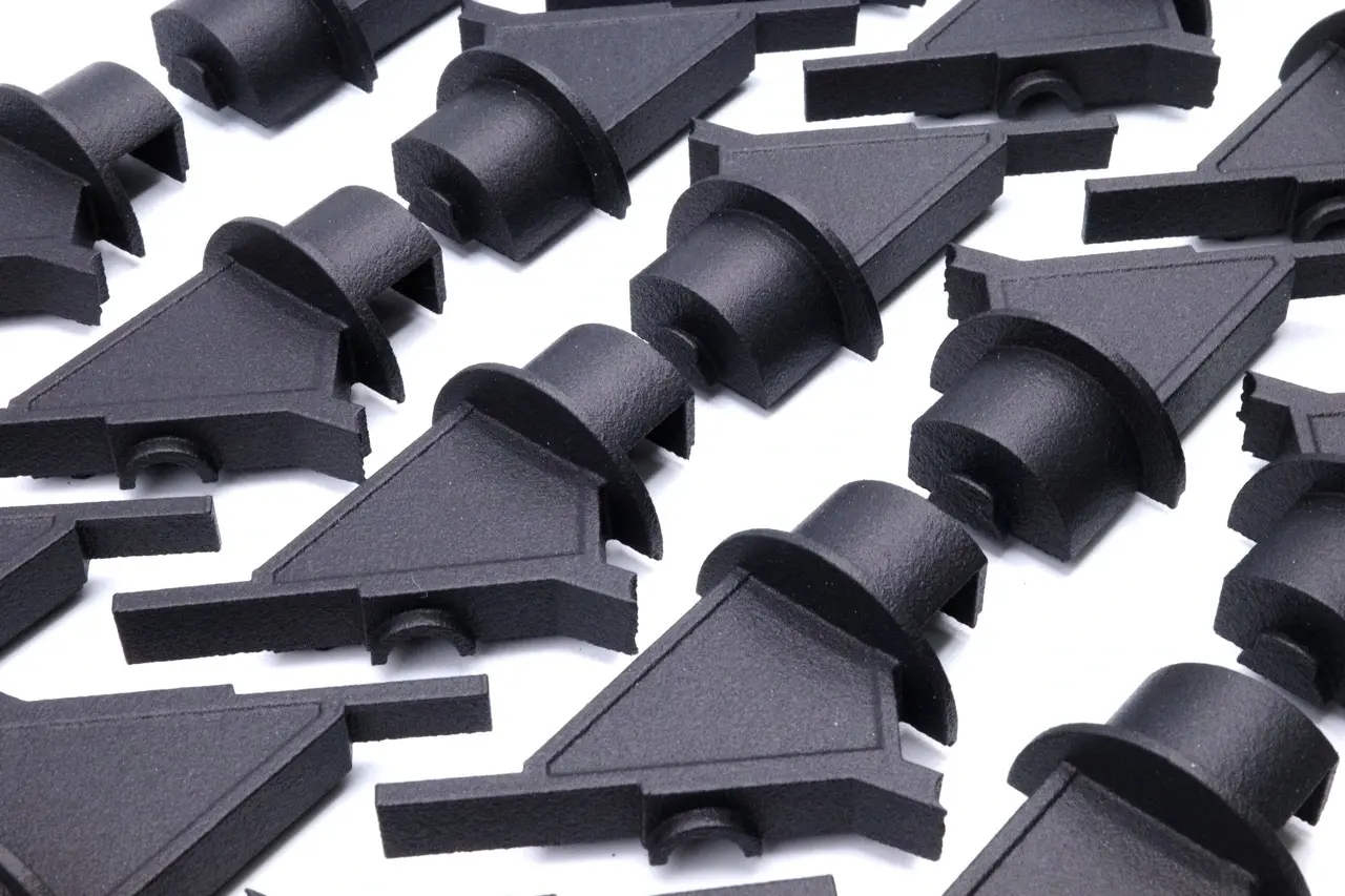 A bunch of black plastic pieces on a white surface