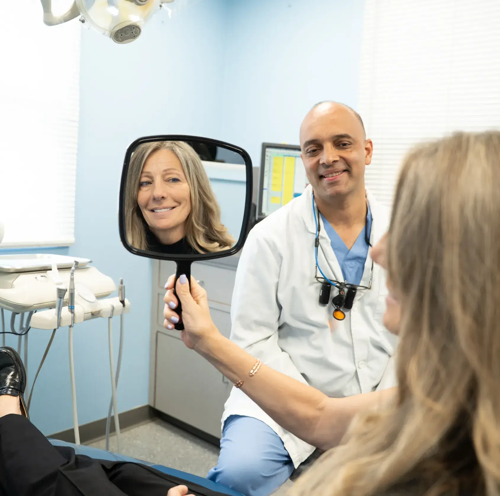 Patient looking dental treatment results in the mirror.