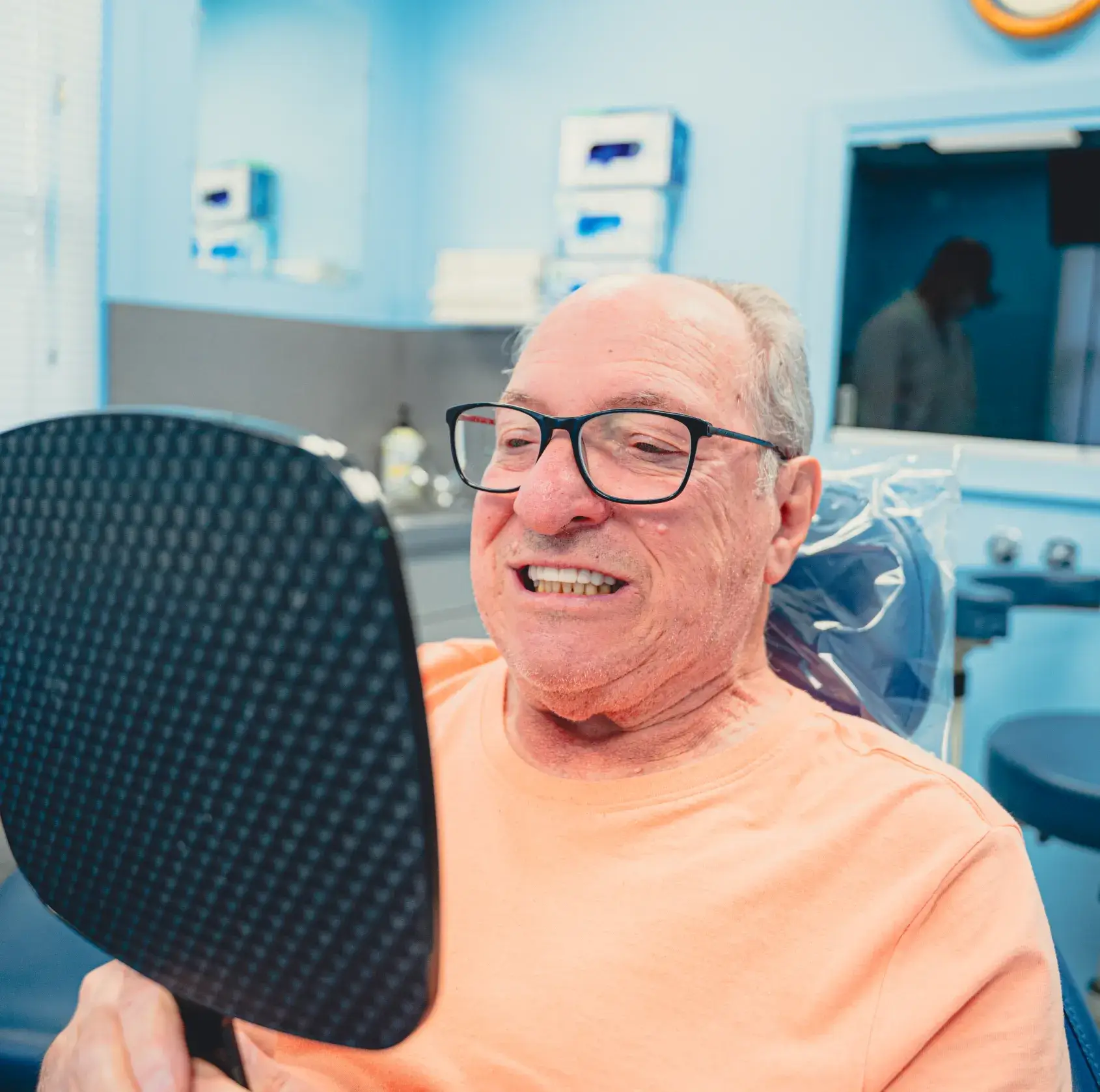 Patient looking dental treatment results in the mirror.