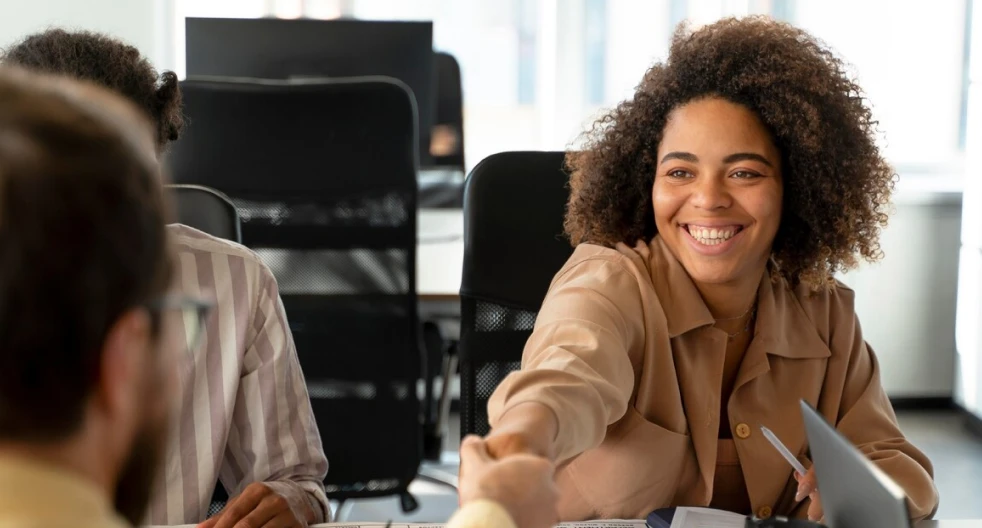 a woman sitting at a table with a laptop computer