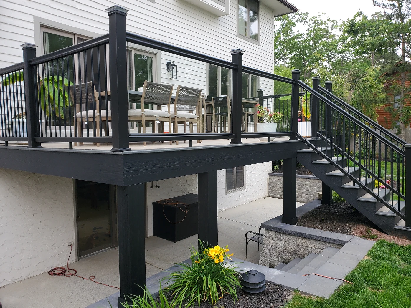 Raised deck with black aluminum railings and stairs at a modern home.