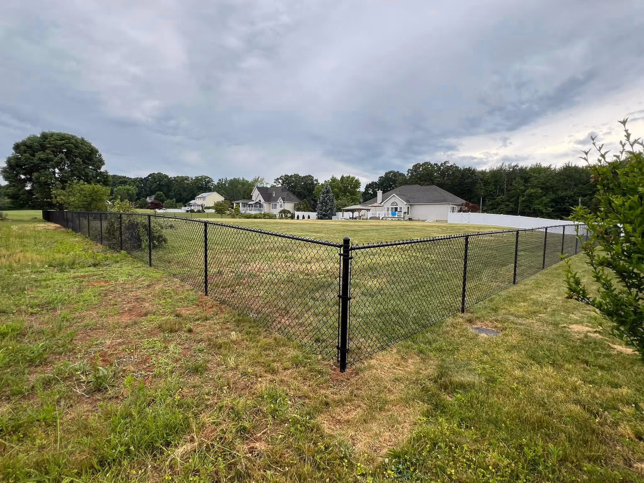 Gray composite deck with black aluminum railings and stairs leading to lawn.
