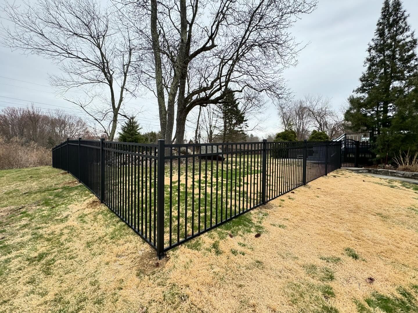 Corner aluminum fence enclosing yard