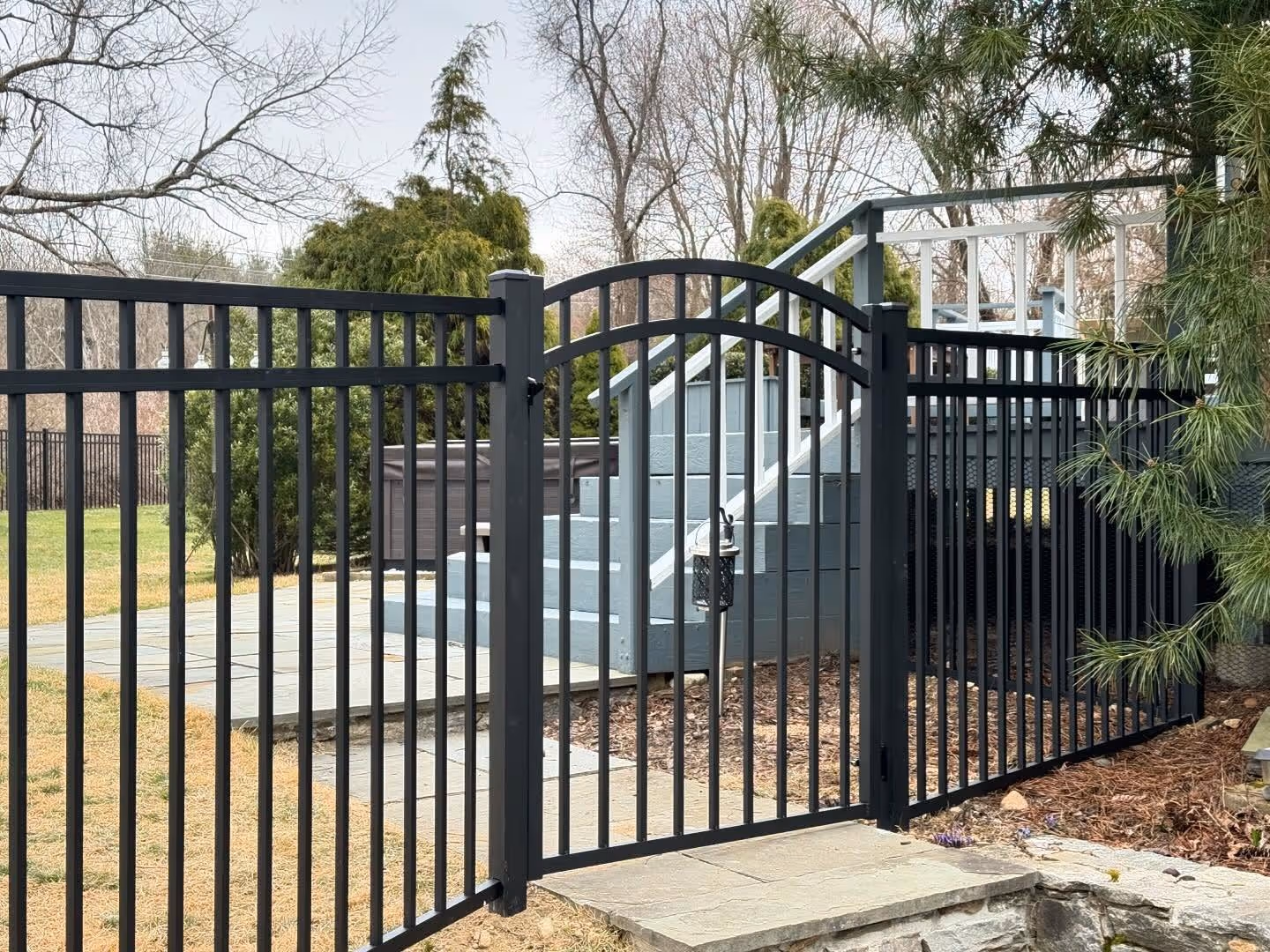 Arched aluminum pool gate near stairs
