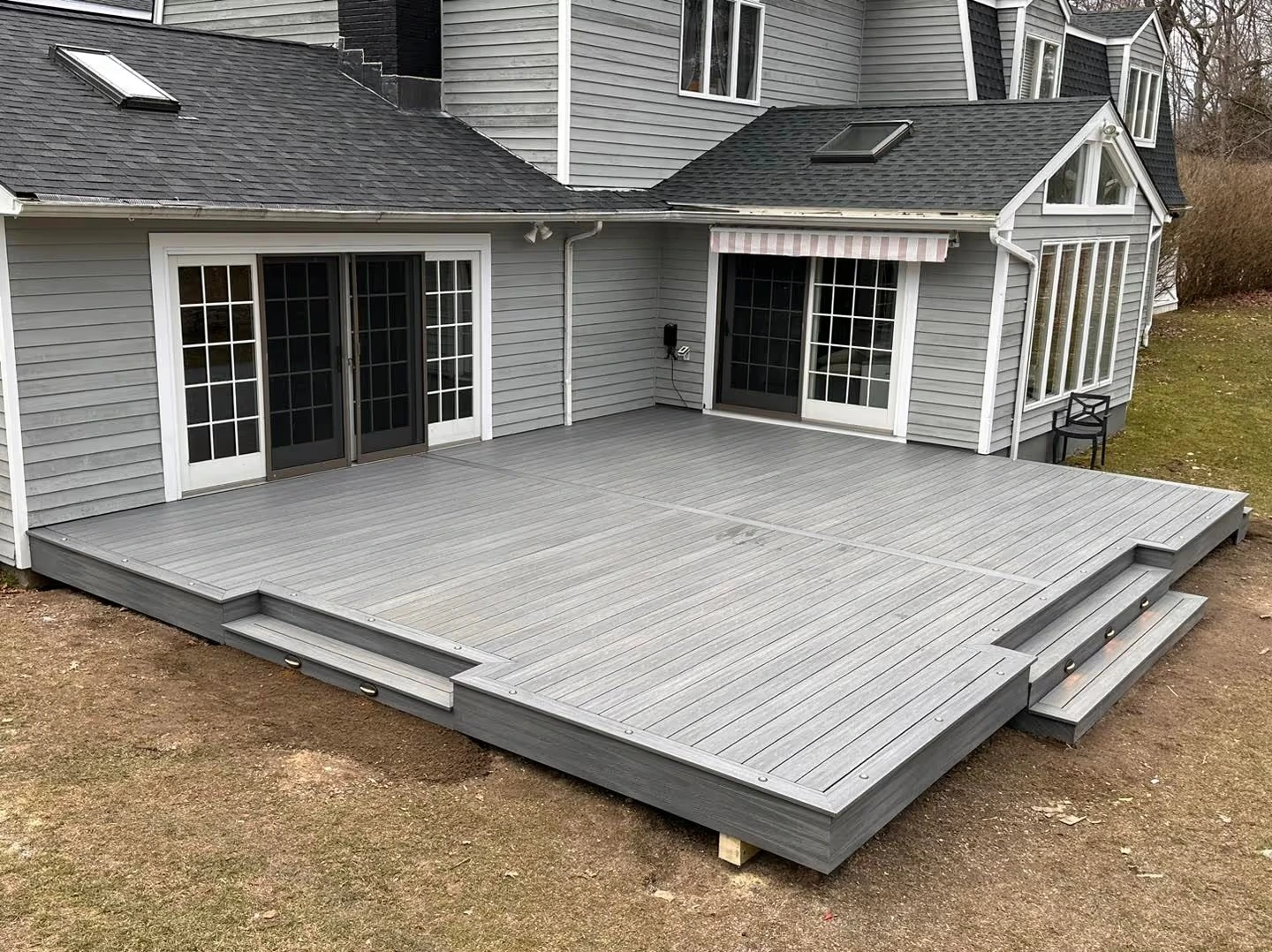 Low platform deck extending from a home into a flat backyard by Tri-State Fence & Deck.