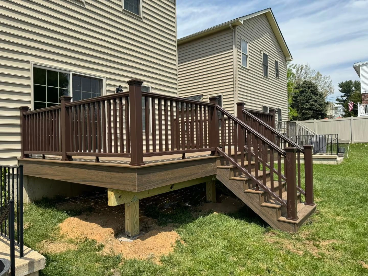 Raised backyard deck with railings and stairs built by Tri-State Fence & Deck.