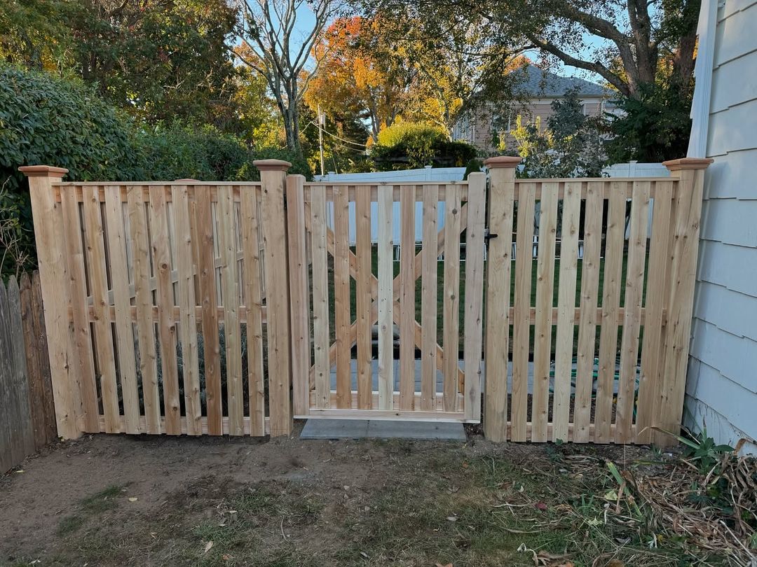 Cedar gate and fence installed beside a home.