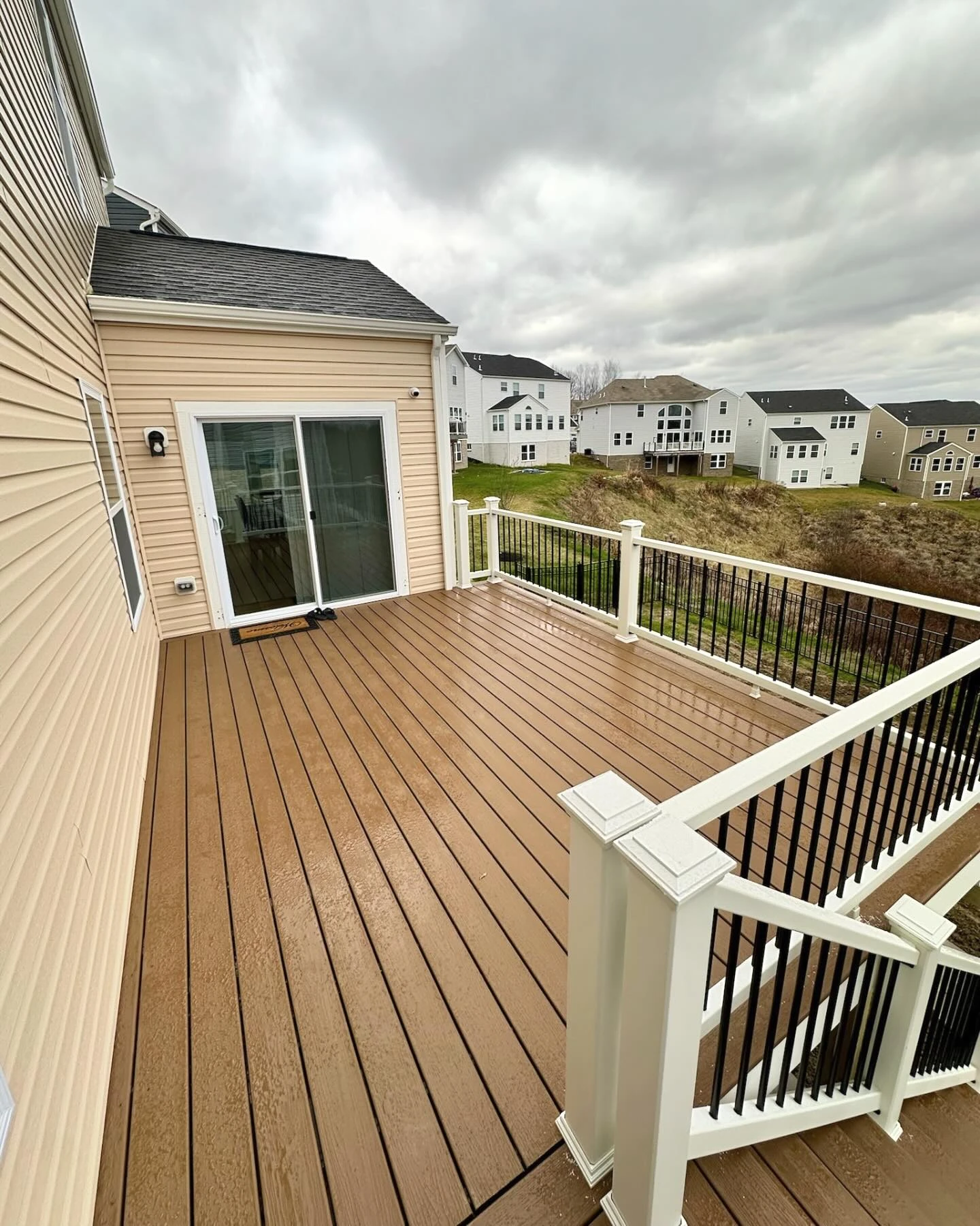 Composite deck with white posts and black balusters built to meet local deck code requirements.