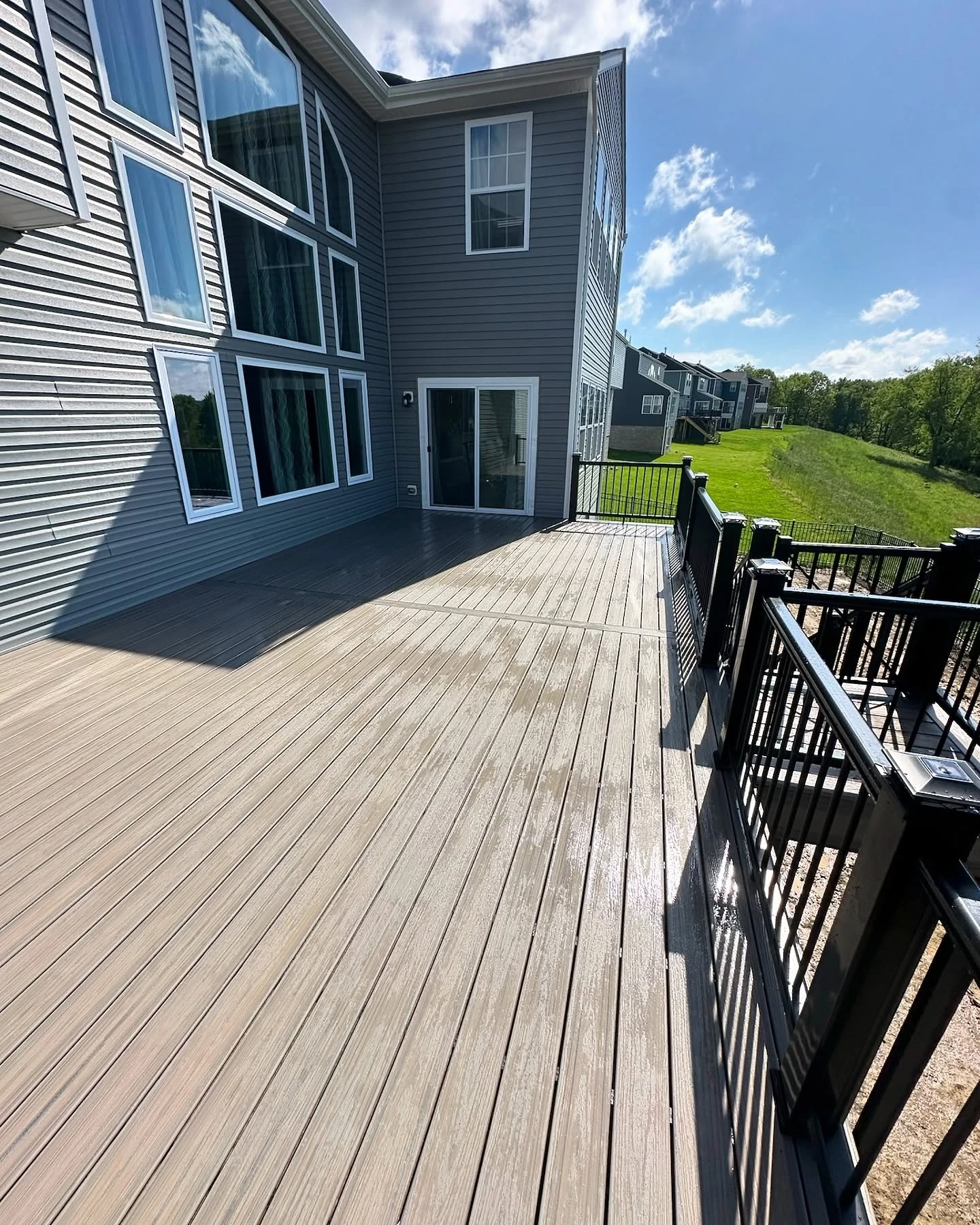 Large composite deck with black aluminum railings completed from a professionally prepared deck plan.