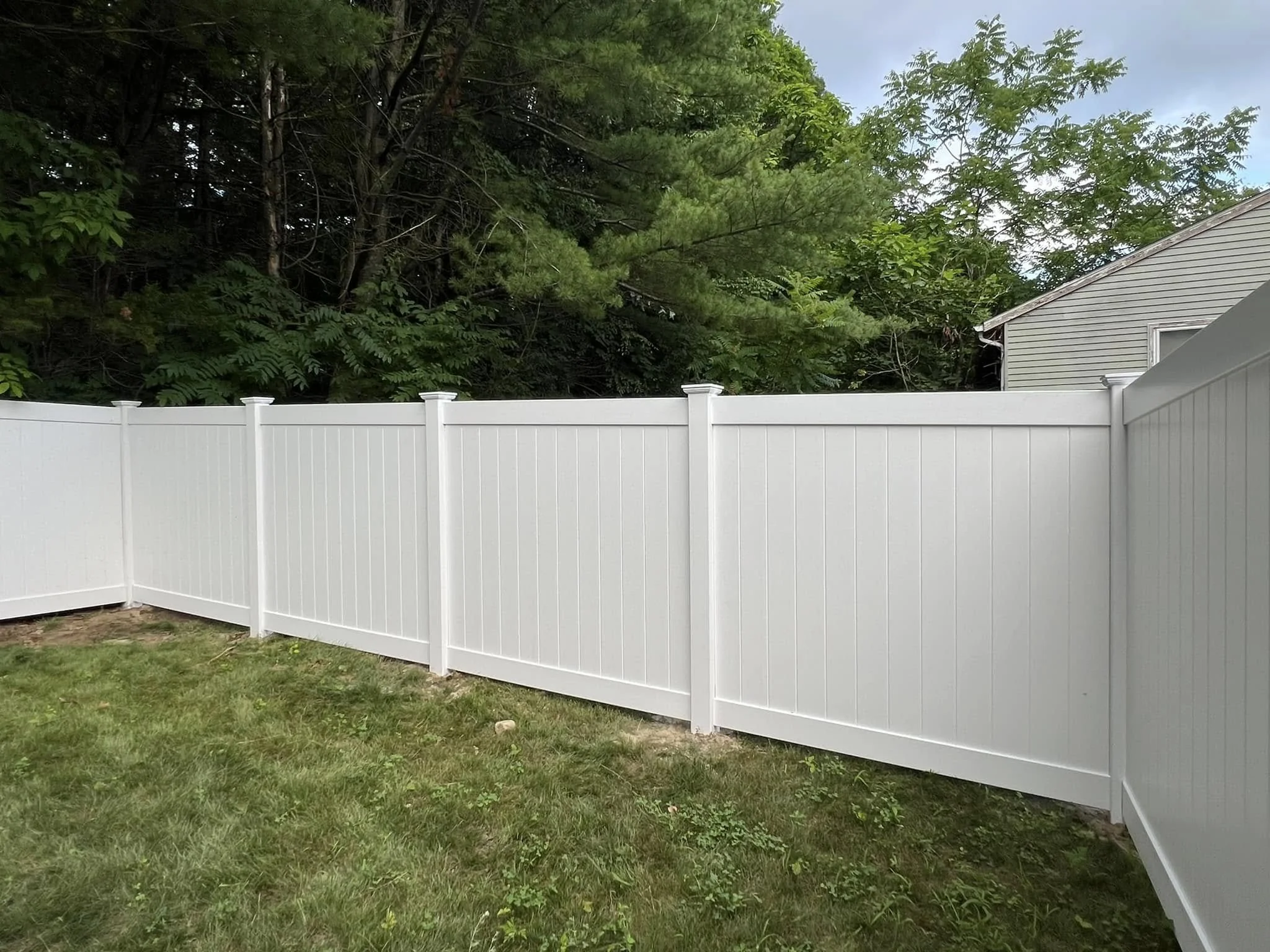White vinyl privacy fence enclosing a backyard in the Tri-State Area.