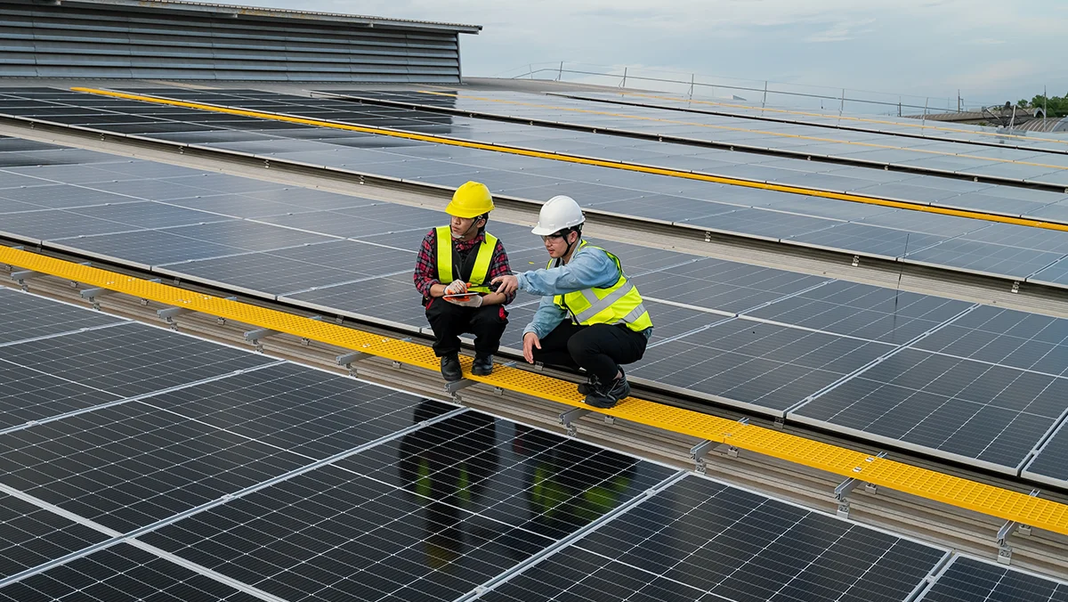 Two workers are reviewing the commercial solar installations.