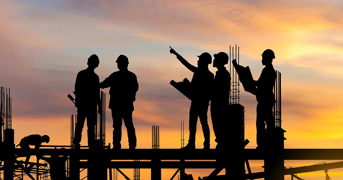 Silhouettes of business owners at a construction site at sunset.
