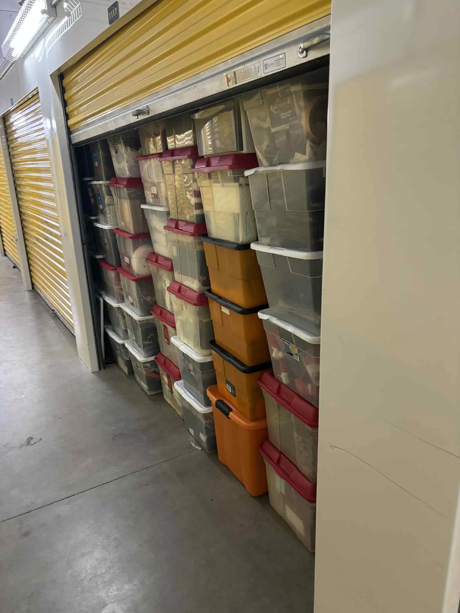 Storage unit with transparent plastic bins and a few orange containers stacked inside the storage in Buffalo, NY