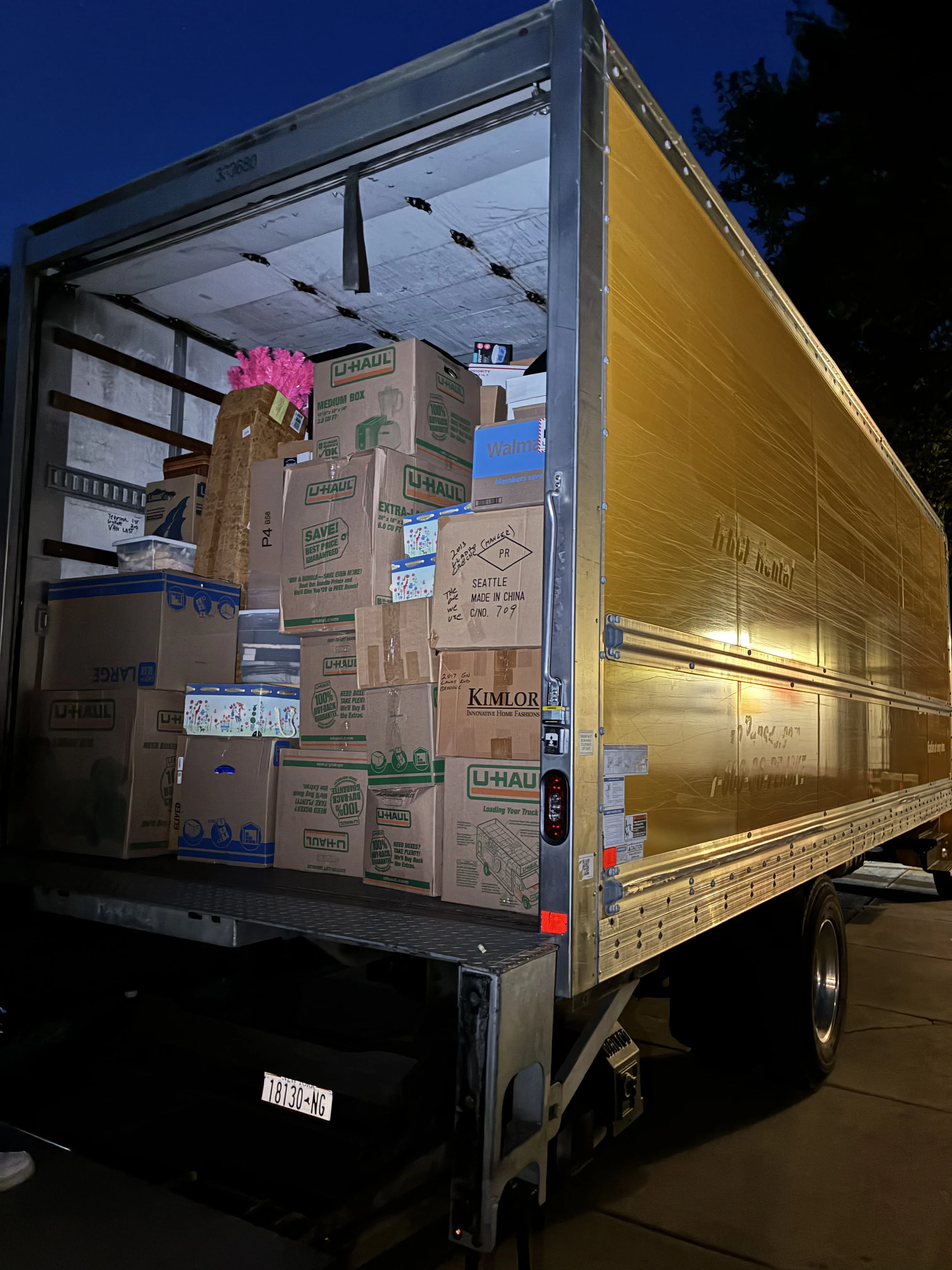 Open U-Haul truck at night loaded with stacked cardboard boxes and packed items for local moving in Buffalo, NY