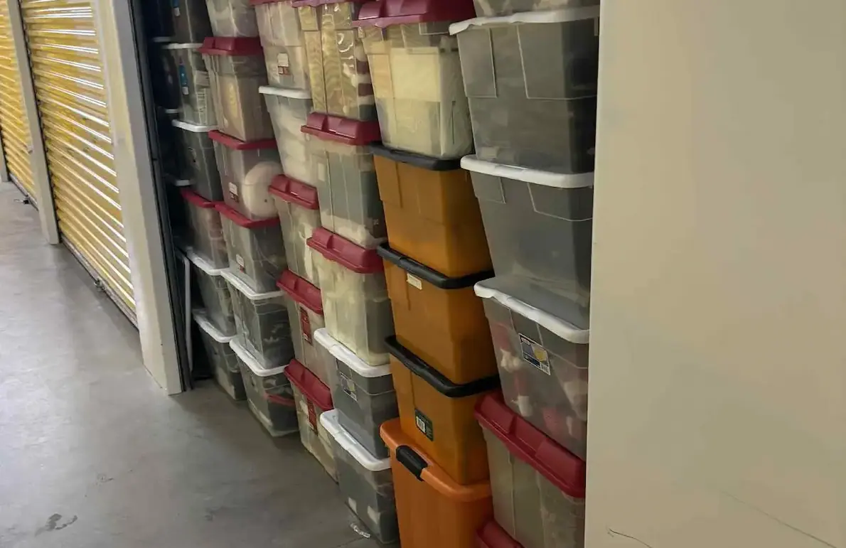 Storage unit with transparent plastic bins and a few orange containers stacked inside the storage in Buffalo, NY