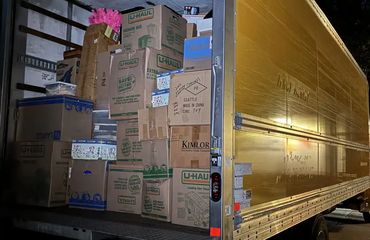 Open U-Haul truck at night loaded with stacked cardboard boxes and packed items for local moving  in Buffalo, NY