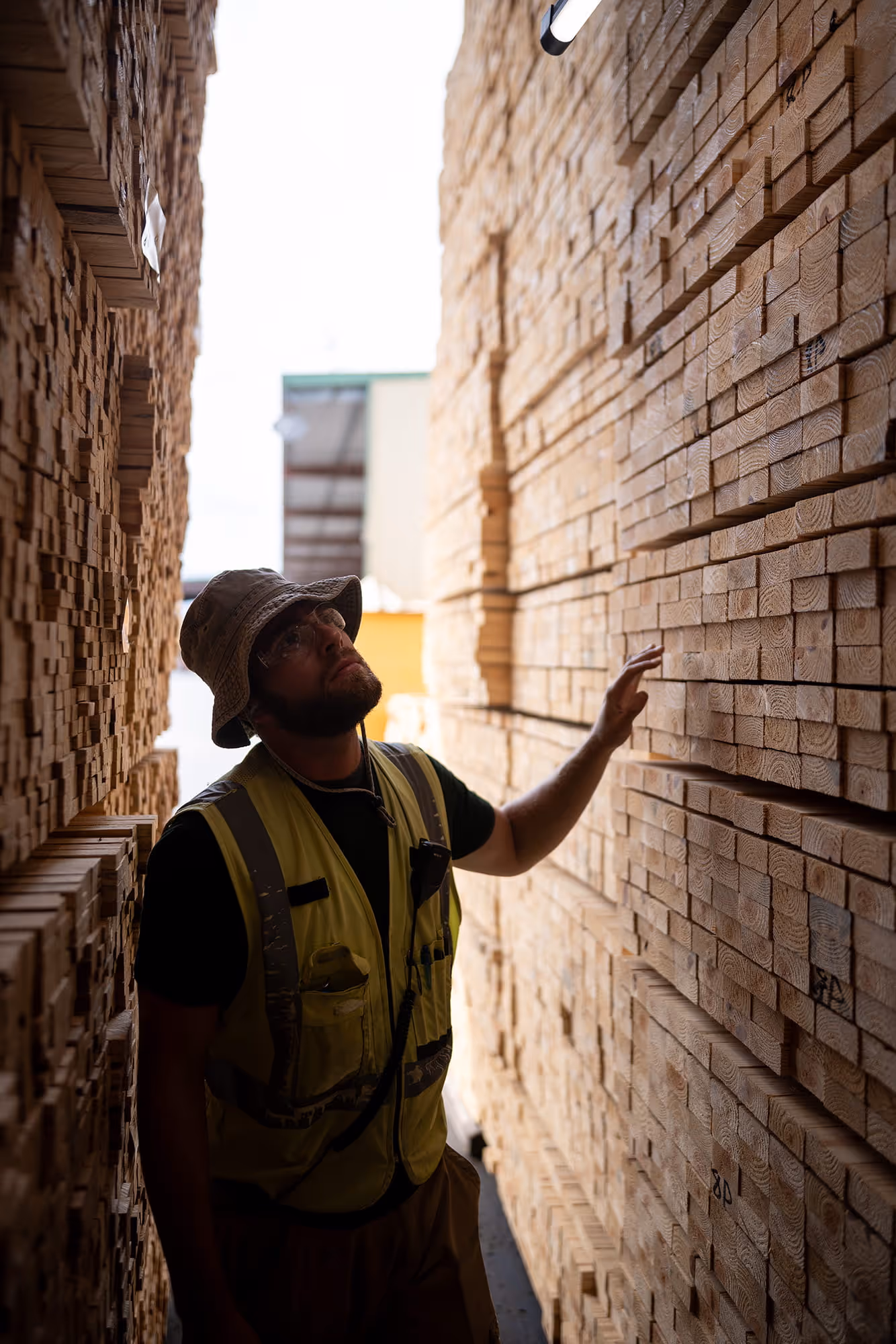 A ProWood employee in between two stacks of pressure treated 2 x 4's.
