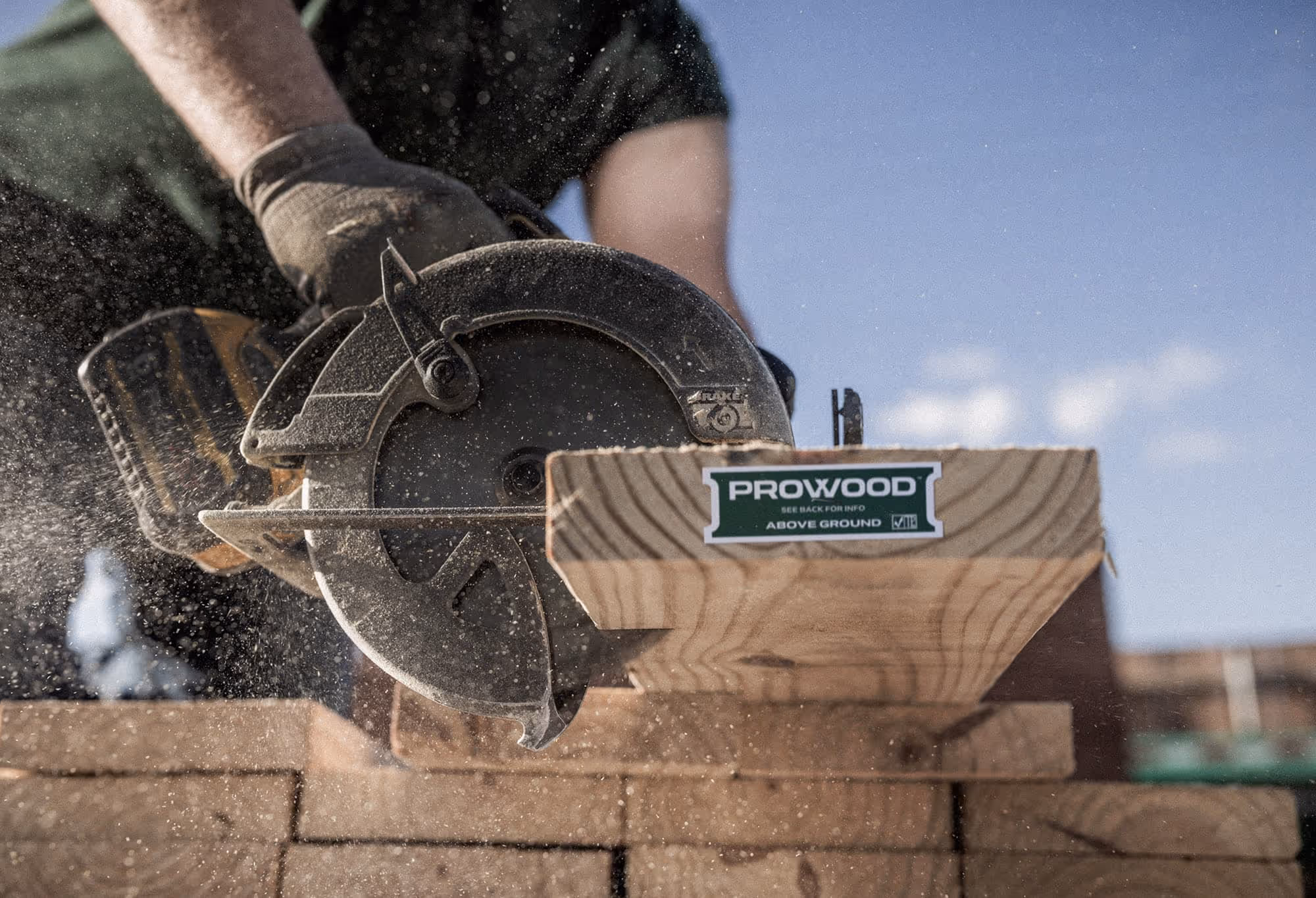 A circular saw cutting a ProWood treated lumber deck board.
