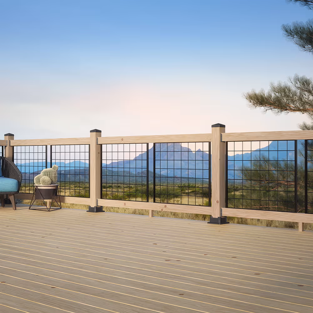 A wood deck in the desert with hogwire railing with mountains in the background.