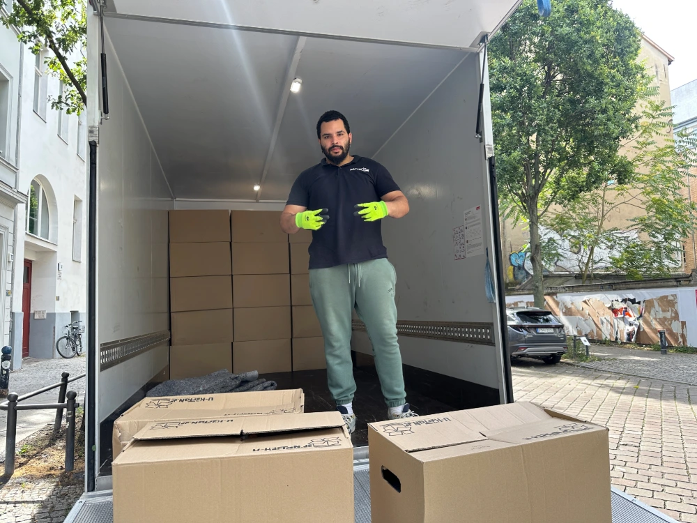 Umzugshelfer mit umzugskartons bei heißem wetter in Berlin Mitte