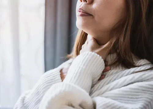 Woman holding her throat in pain
