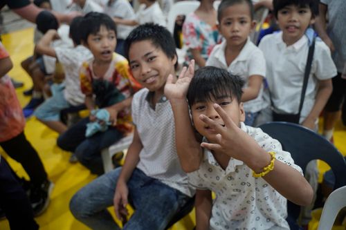 Young boys waving to the camera