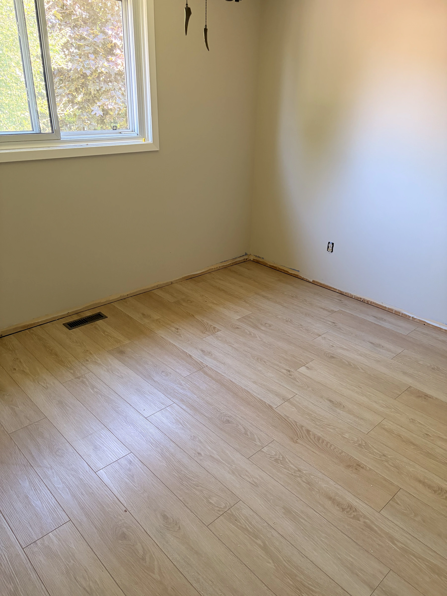 Light wood-look plank flooring installed in a room before trim is fitted