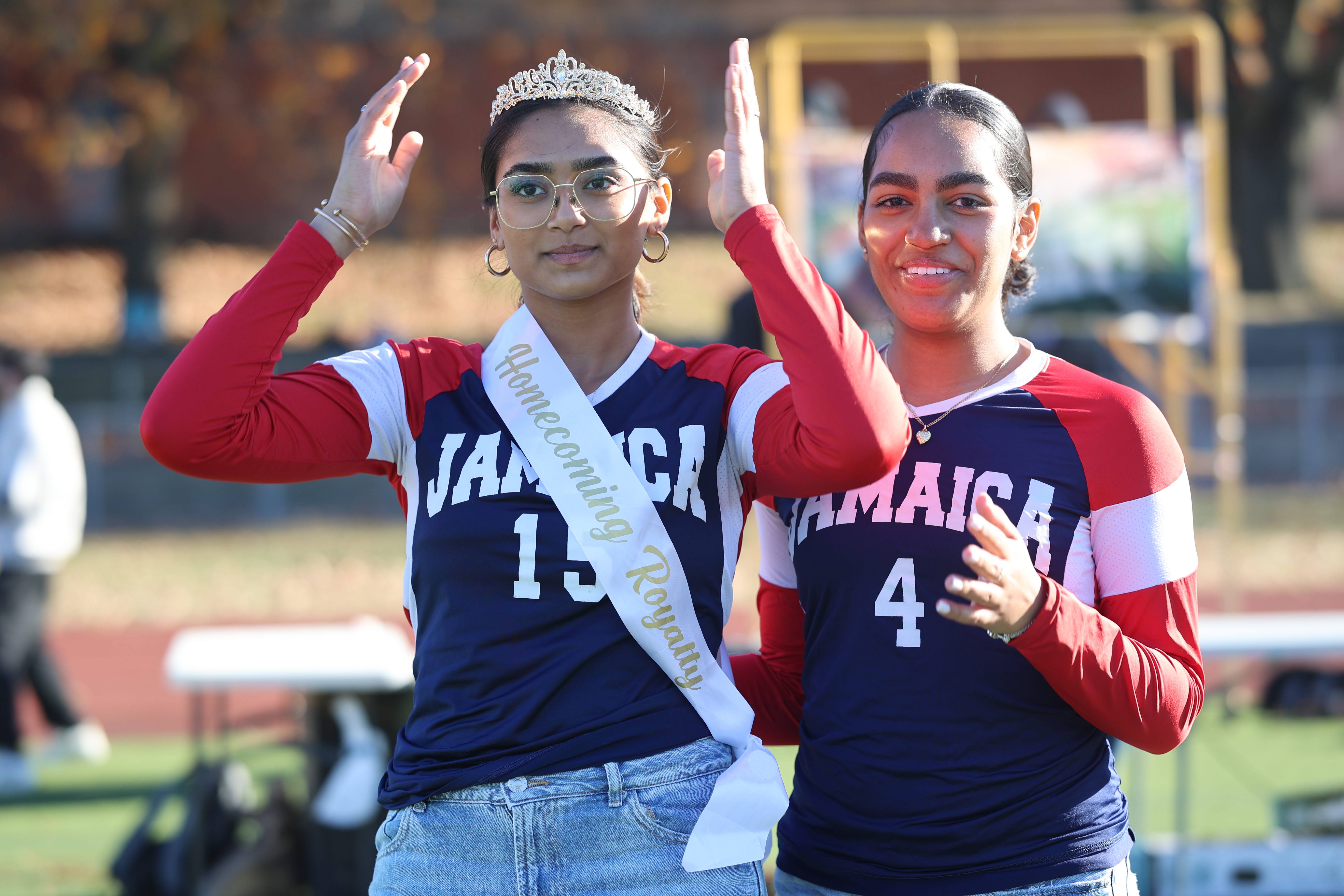 Two Jamaica High School students celebrate homecoming queen coronation on field