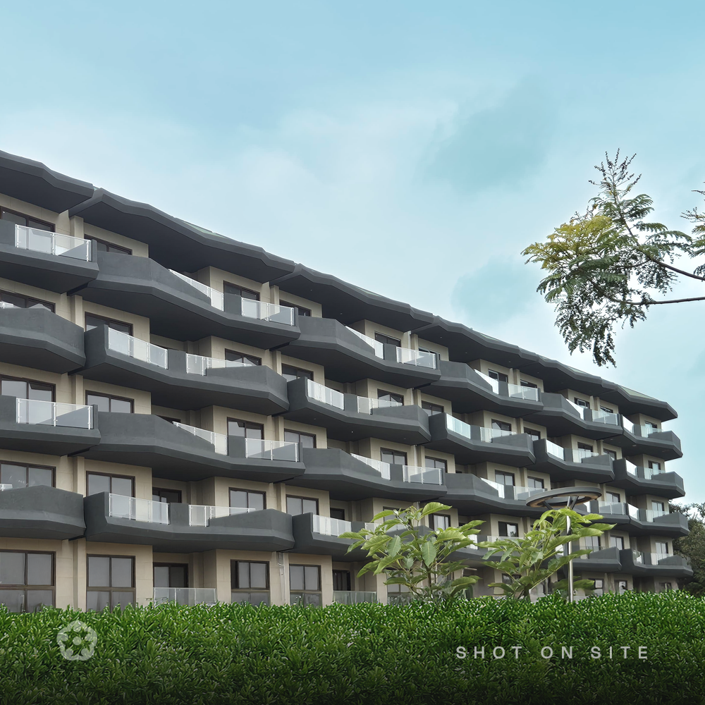 Completed low-rise residential facade with landscaped hedge at a JRC Projects luxury community on Sarjapura Road, Bangalore, photographed on site