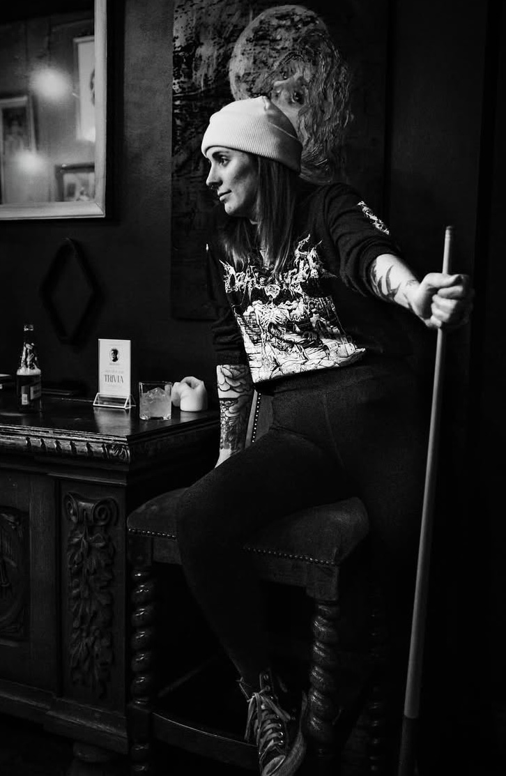 Black and white photo of Chey with a pool cue