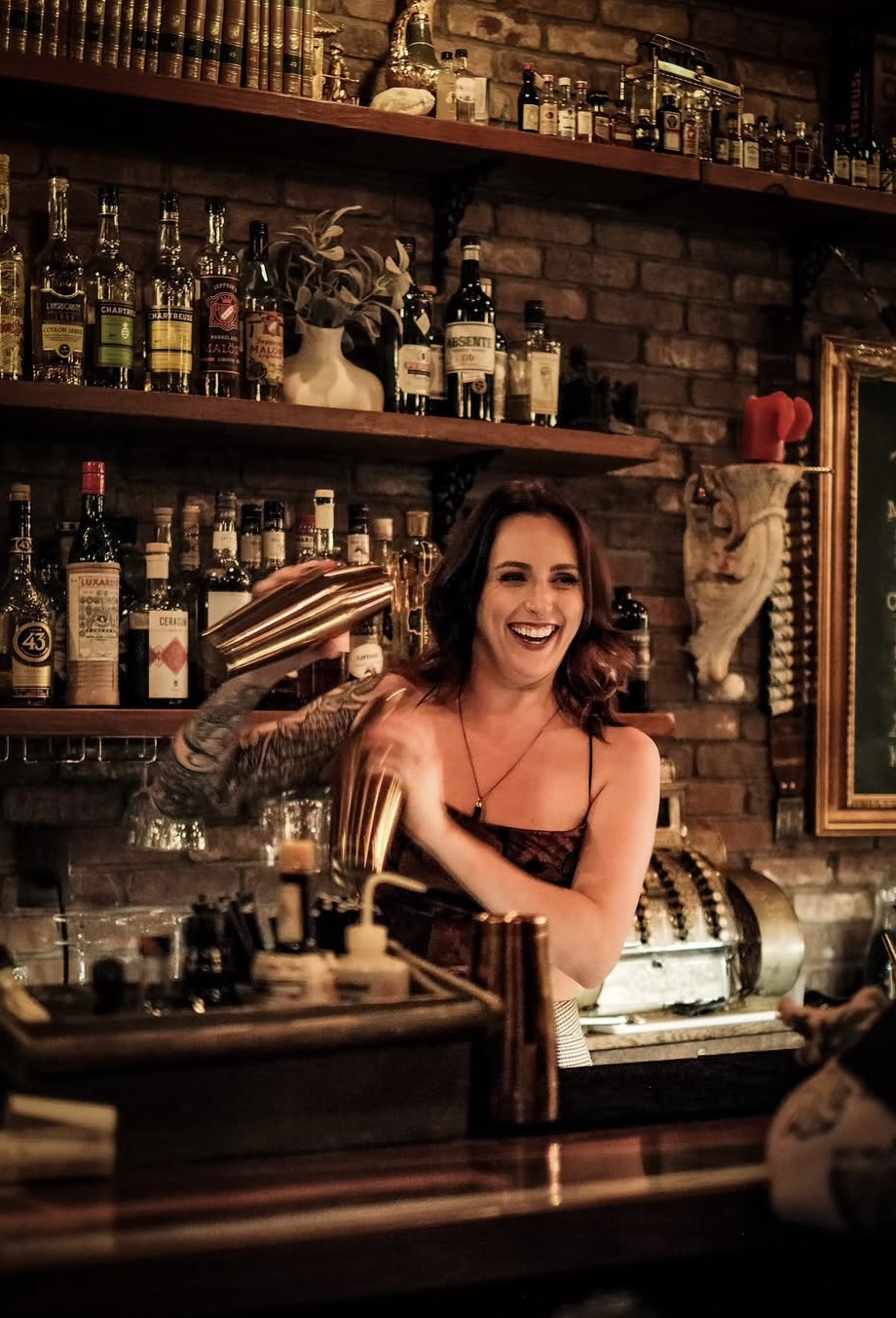 Chey shaking a cocktail with a smile