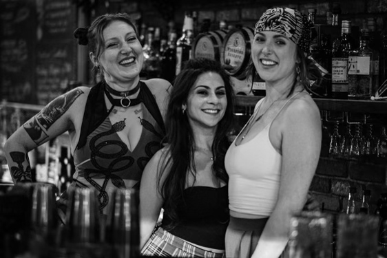 Black and white photo of all the female bar staff behind the bar