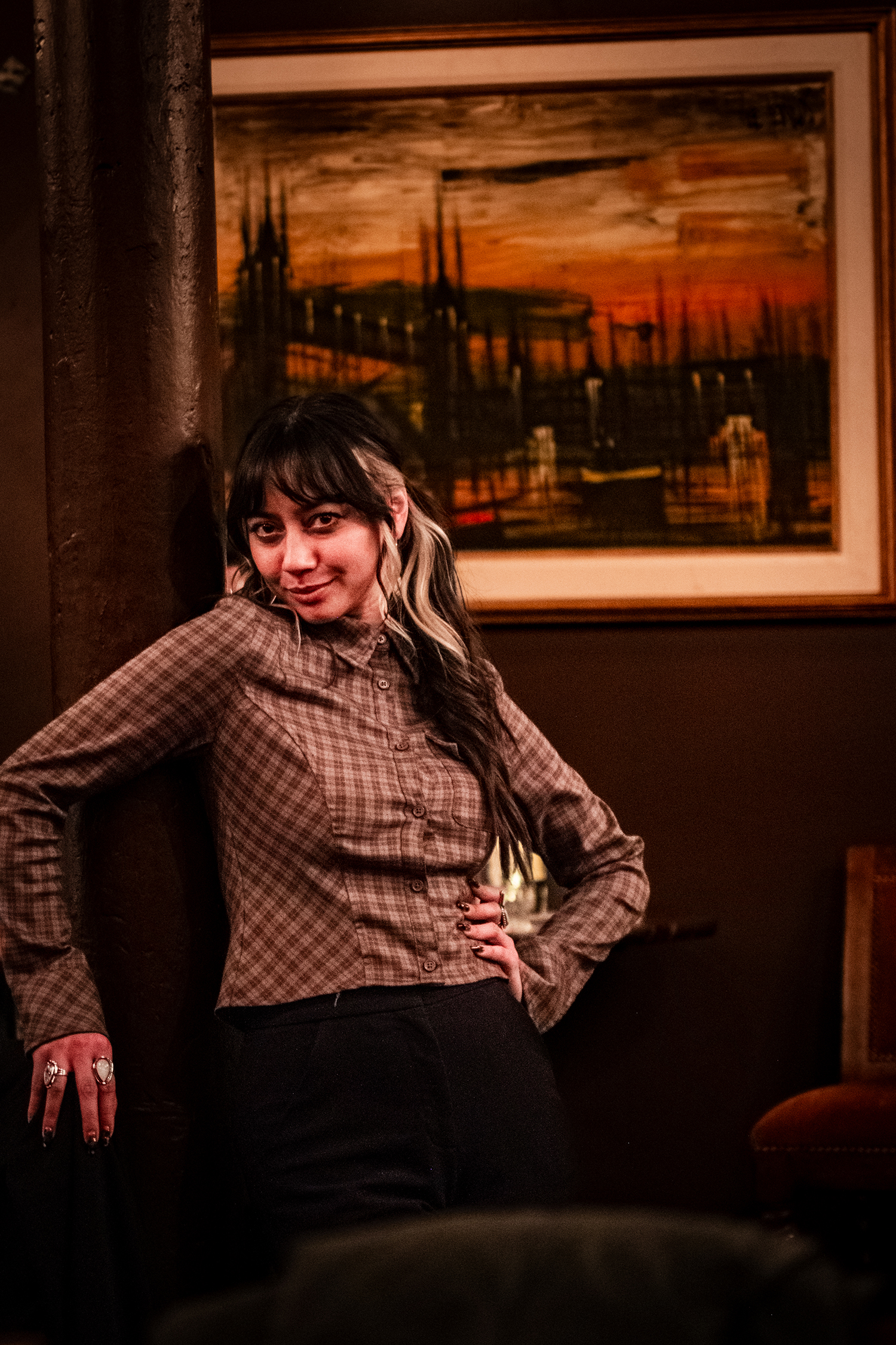 A patron with an oil painting in the background