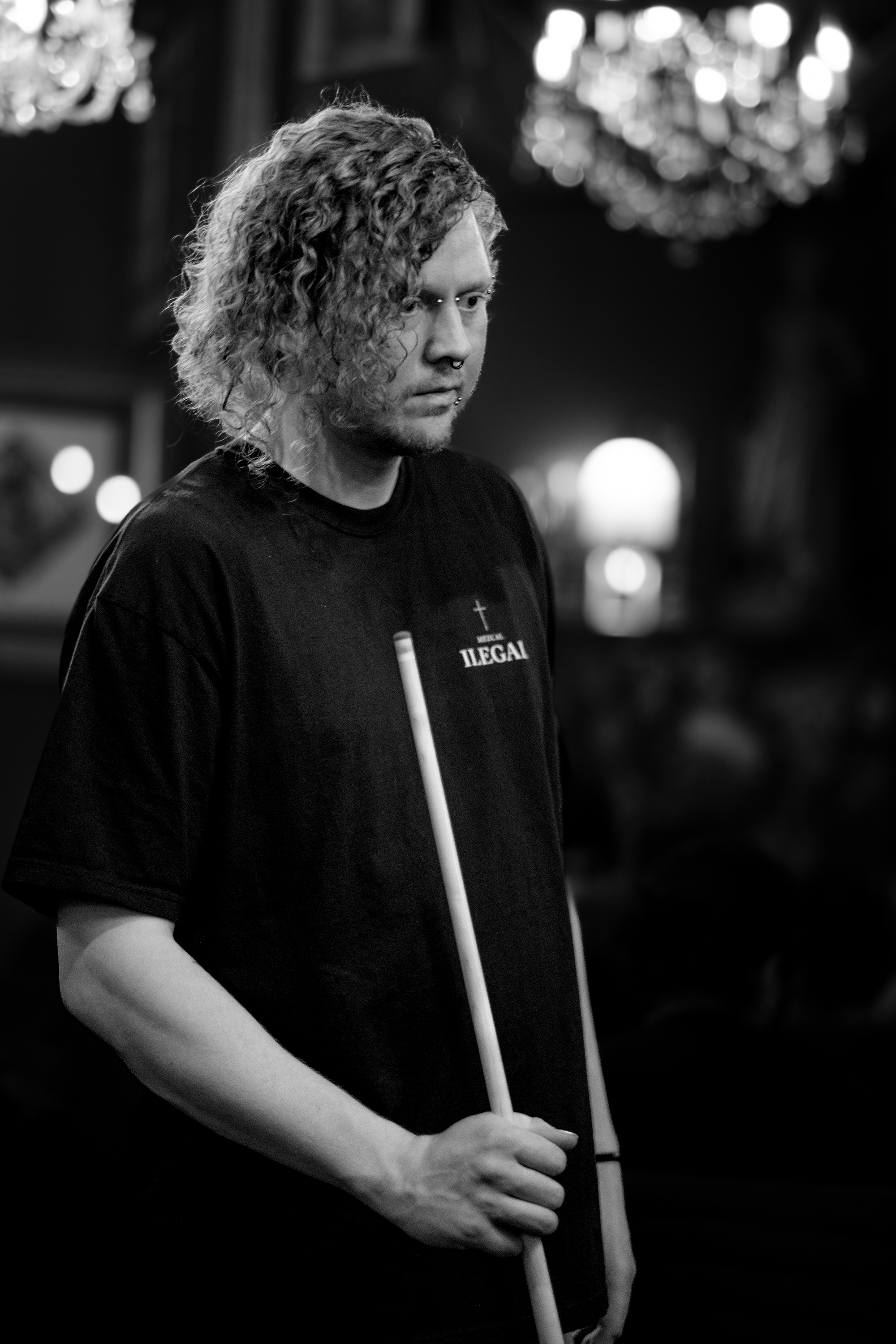 Server Sean holding a pool cue, examining the pool table