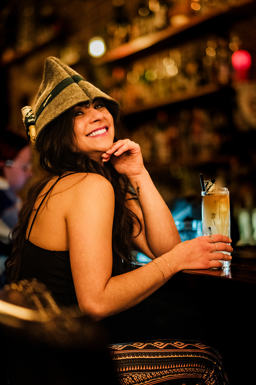 Beck wearing an Underberg hat holding a gin cocktail