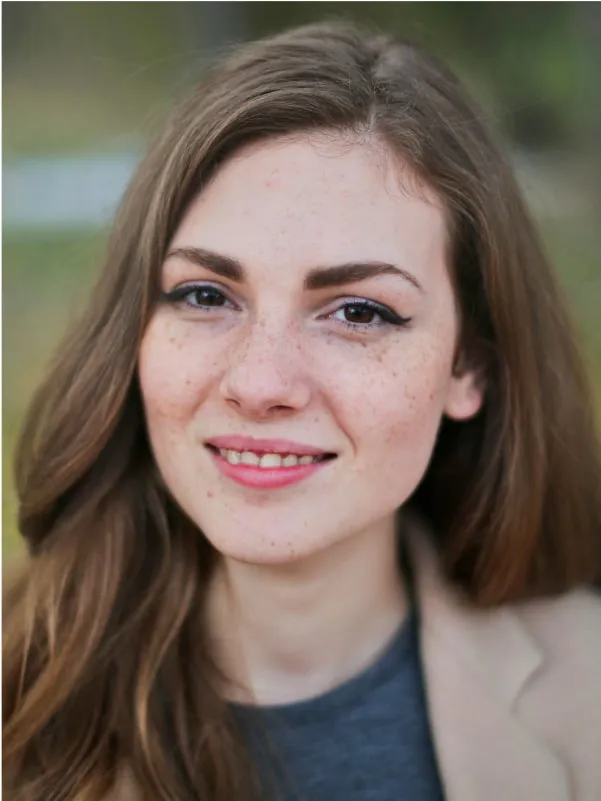 woman wearing beige blazer smiling looking at camera