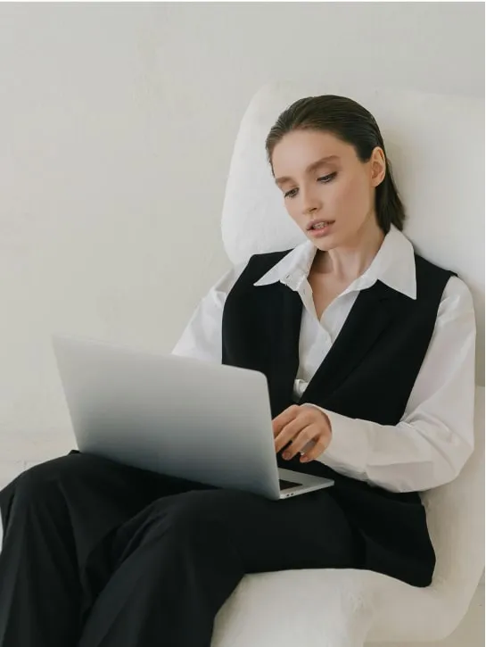 woman sitting on sofa working with laptop