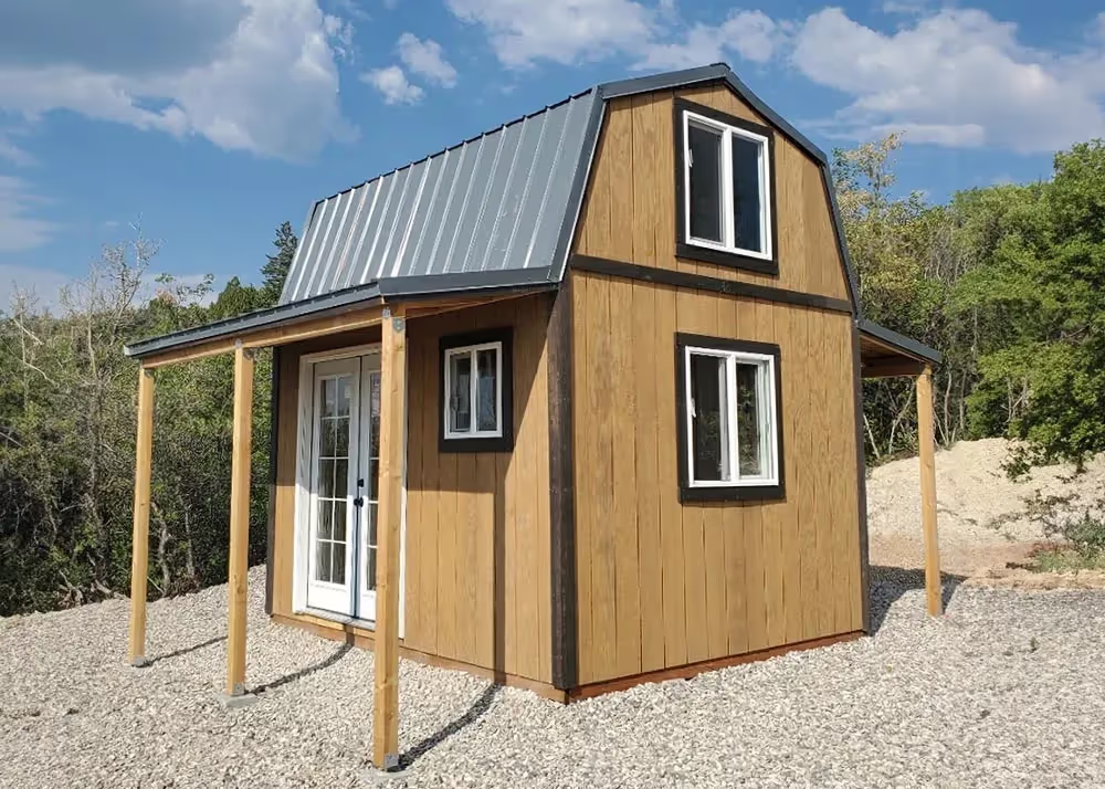 A 10 foot by 12 foot Tall Barn cabin shed with double porch overhangs