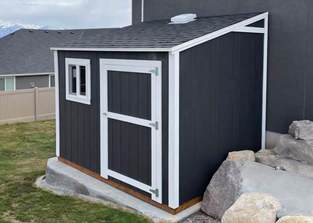 An 8 foot by 10 foot Lean-To Storage shed with a window that is up against a house