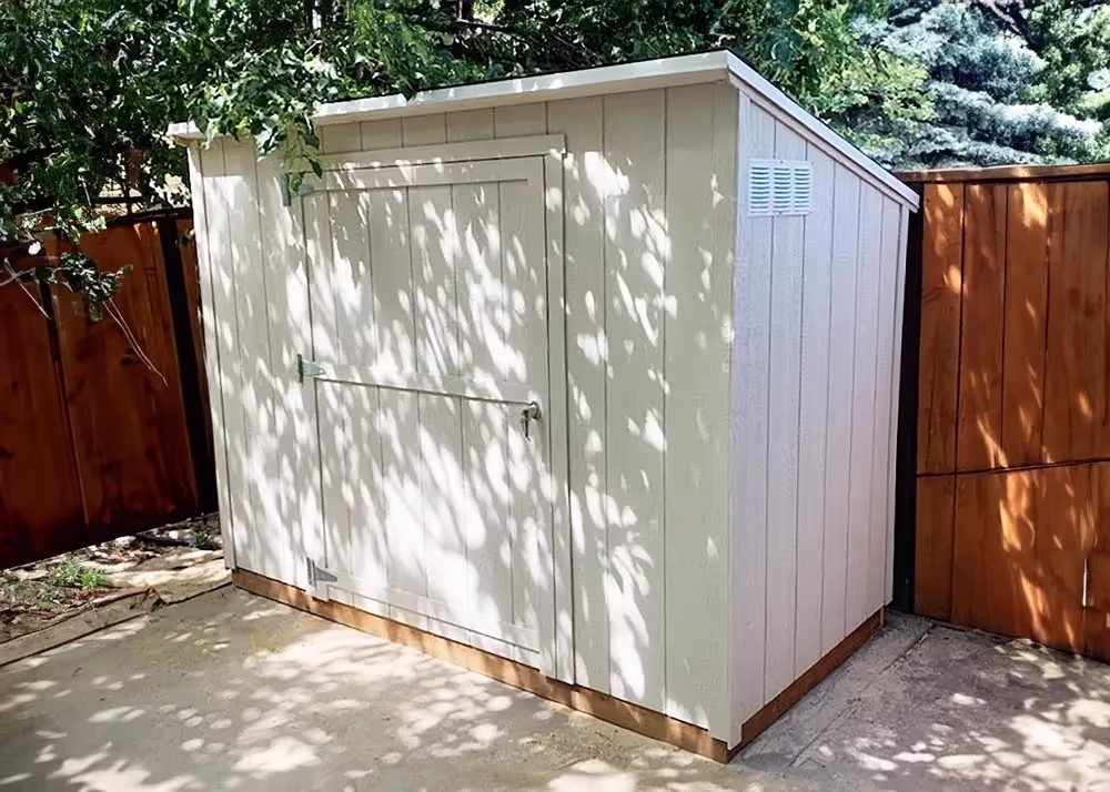 An off white 4 foot by 8 foot Yard Hutch Storage Shed