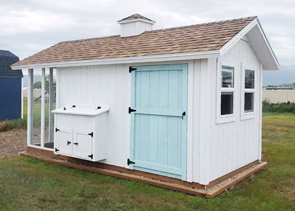 A white and aqua Coop De'Ville Chicken coop and storage shed combination. 