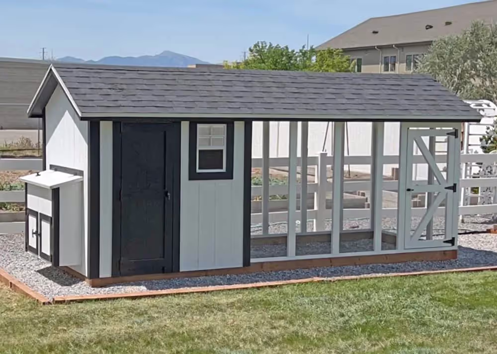 A 6 foot by 14 foot Coop De'Ville chicken Coop in white and black with a s solid black door