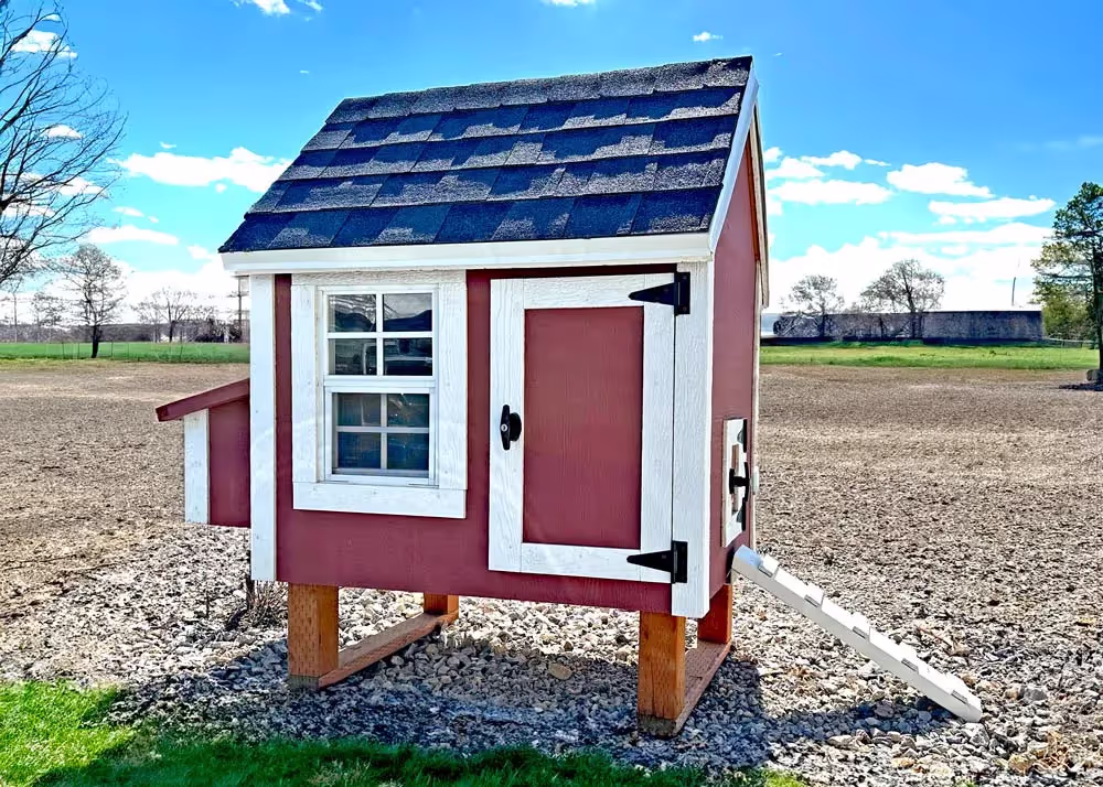 A red and white small hen hut chicken coop with a ramp